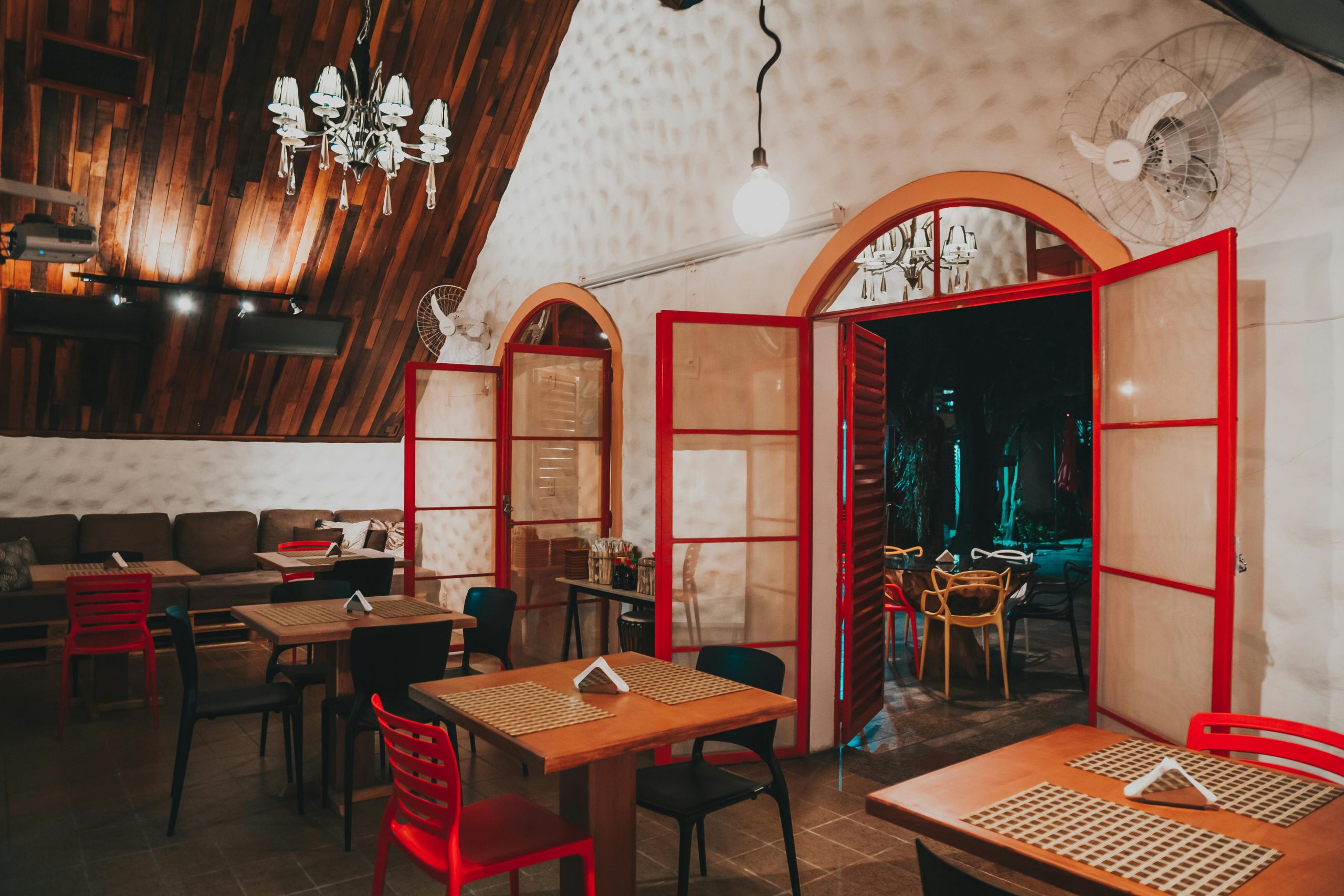 Home Warm and inviting restaurant interior featuring wooden details and red accents for a cozy atmosphere.