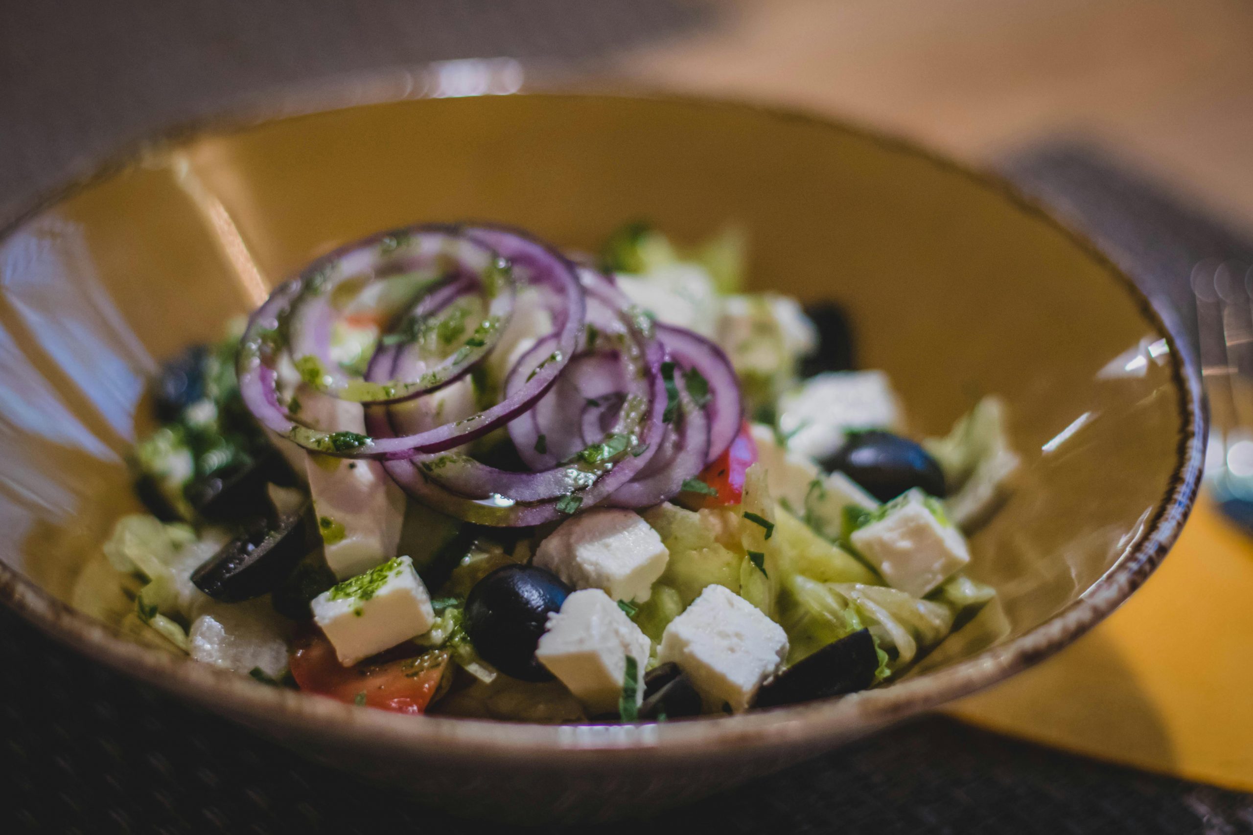 Home A mouth-watering Greek salad featuring fresh feta, black olives, and red onion rings.